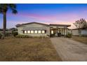 Front view of a single-wide manufactured home at dusk at 1435 Mohawk Cir, Tavares, FL 32778