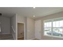 Bright and airy entryway with stairs, coat closet, and window at 16436 Hamlin View St, Winter Garden, FL 34787
