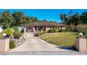 Front view of a ranch home with a landscaped yard and a paved driveway at 316 Amanda Ln, Leesburg, FL 34748