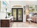 Bright entryway with double doors, tile floors, and a console table at 6147 Spinnaker Loop, Lady Lake, FL 32159