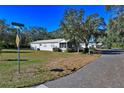 Mobile home on a tree-lined street at 11642 Martell Ct, Leesburg, FL 34788