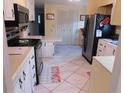 Galley kitchen with stainless steel appliances and light-colored cabinetry at 117 Hibiscus Way, Leesburg, FL 34748