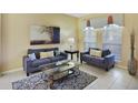 Cozy living room featuring two sofas, a coffee table, and large windows at 151 Rubino Dr, Davenport, FL 33837