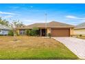 Single-story house with brown roof, attached garage, and well-maintained lawn at 17329 Se 115Th Terrace Rd, Summerfield, FL 34491