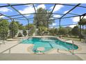 Inviting kidney-shaped pool with a screened enclosure, perfect for relaxation at 2126 Lake Ridge Dr, The Villages, FL 32162