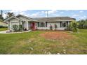 Gray house with red door, landscaped yard, and driveway at 2183 Croat St, Mount Dora, FL 32757