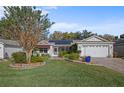 House exterior featuring a manicured lawn and a two-car garage at 3550 Auburndale Ave, The Villages, FL 32162