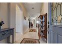 Bright entryway with tiled floor and antique curio cabinet at 5717 Illumination Ln, Leesburg, FL 34748