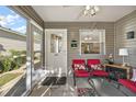 Inviting screened porch with seating area and door leading to main living space at 8173 Se 169Th Palownia Loop, The Villages, FL 32162