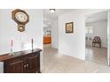 Bright entryway with tiled floor, wooden console table, and view to kitchen at 893 Parrish Pl, The Villages, FL 32163