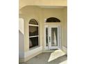 Front entry with arched windows and a white door at 1270 Addison Ave, The Villages, FL 32162