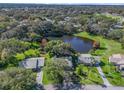 Aerial view showcasing a community with houses and a pond at 1310 Moray Ct, Leesburg, FL 34788