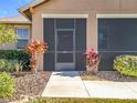 Screened porch entrance with decorative plants and a concrete walkway at 16304 Spring View Ct, Clermont, FL 34711