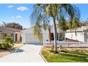 Front view of a white house with a palm tree and white picket fence at 17288 Se 93Rd Heyward Ave, The Villages, FL 32162