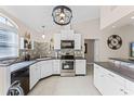 Modern kitchen with white cabinets, stainless steel appliances, and dark countertops at 240 Citrus Wood Ct, Davenport, FL 33837