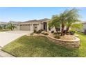Attractive curb appeal with palm trees, a two-car garage, and a well-maintained lawn at 3766 Causey Ct, The Villages, FL 32163
