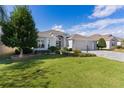 Single-story house with a two-car garage, lush lawn, and stone accents at 747 Bradford Loop, The Villages, FL 32163
