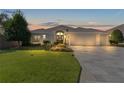 Attractive single-story home with a large driveway and well-manicured lawn at 747 Bradford Loop, The Villages, FL 32163