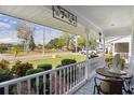 Covered porch with white railings, offering a relaxing view of the neighborhood at 950 Beaver Run, Tavares, FL 32778