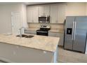 Modern kitchen featuring stainless steel appliances, ample counter space, and stylish cabinetry at 964 Rivers Crossing St, Clermont, FL 34714