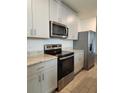 Well-equipped kitchen with sleek appliances, light gray cabinets, and wood-look tile flooring at 964 Rivers Crossing St, Clermont, FL 34714