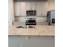 Kitchen island with granite countertops, stainless steel appliances, and a double sink at 964 Rivers Crossing St, Clermont, FL 34714