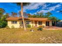 Yellow ranch home with a large yard and palm tree at 11451 Pala Verda Ave, Leesburg, FL 34788