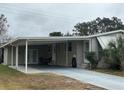 Mobile home with carport, covered walkway and landscaped yard at 1335 E Schwartz Blvd, Lady Lake, FL 32159
