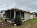 Mobile home with screened porch and partial view of the backyard at 1335 E Schwartz Blvd, Lady Lake, FL 32159