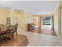 Open living area with wood-look floors, tile, a dining table, piano, and backyard access at 3556 Creek Run Ln, Eustis, FL 32736