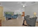 Spacious living room with tile floors and blue couches at 4318 St Stephen St, The Villages, FL 32163