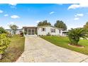 Home exterior with paved driveway and landscaping at 811 Saint Andrews Blvd, The Villages, FL 32159