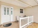 Front entrance with white door and two-striped chairs at 9199 Se 171St Cooper Loop, The Villages, FL 32162