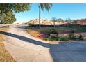 Curved driveway leading to house with landscaping and distant construction at 9835 Lakeshore Dr, Clermont, FL 34711