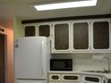 White appliances and dark brown cabinets at 101 Mango Cv, Leesburg, FL 34748