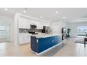 Modern kitchen with island, stainless steel appliances, and blue cabinetry at 1115 Calico Pointe Cir, Groveland, FL 34736