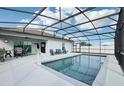 Inviting pool area with covered patio, comfortable seating, and a built-in grill at 1115 Calico Pointe Cir, Groveland, FL 34736
