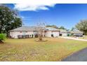 Ranch-style home with a two-car garage and well-maintained lawn at 202 Forest Park Ln, Lady Lake, FL 32159