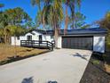 White house with black accents, a driveway, and a black fence at 30033 W Thyme Ave, Eustis, FL 32736