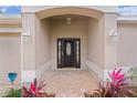 Inviting front entrance with a dark-stained door and brick walkway at 3614 Kingswood Ct, Clermont, FL 34711