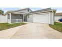 View of the garage and backyard, showing a concrete driveway and grassy area at 4056 Venetian Ln, The Villages, FL 32163