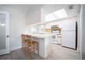 White kitchen with breakfast bar and light wood floors at 4566 County Road 116, Wildwood, FL 34785