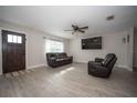 Spacious living room with dark leather furniture and large TV at 4566 County Road 116, Wildwood, FL 34785