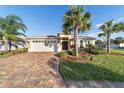 Single-story house with a white garage door and palm trees at 10349 Silver Maple Ave, Oxford, FL 34484