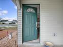 Inviting teal front door opening to a well-lit home at 32314 Oak Park Dr, Leesburg, FL 34748