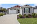 Gray house with red accents and a two-car garage at 5820 Bamboo Ave, The Villages, FL 32163