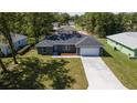 Newly built house with a gray roof, driveway, and spacious yard at 91 Locust Loop, Ocala, FL 34472