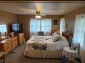 Spacious bedroom with large bed and wood-paneled walls at 975 Cr 461, Lake Panasoffkee, FL 33538