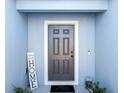 Gray front door with white trim and 'Home Sweet Home' decor at 1109 Catskill Dr, Haines City, FL 33844