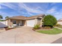 Single-story home with a two-car garage and landscaped yard at 2243 Montbrook Pl, The Villages, FL 32162